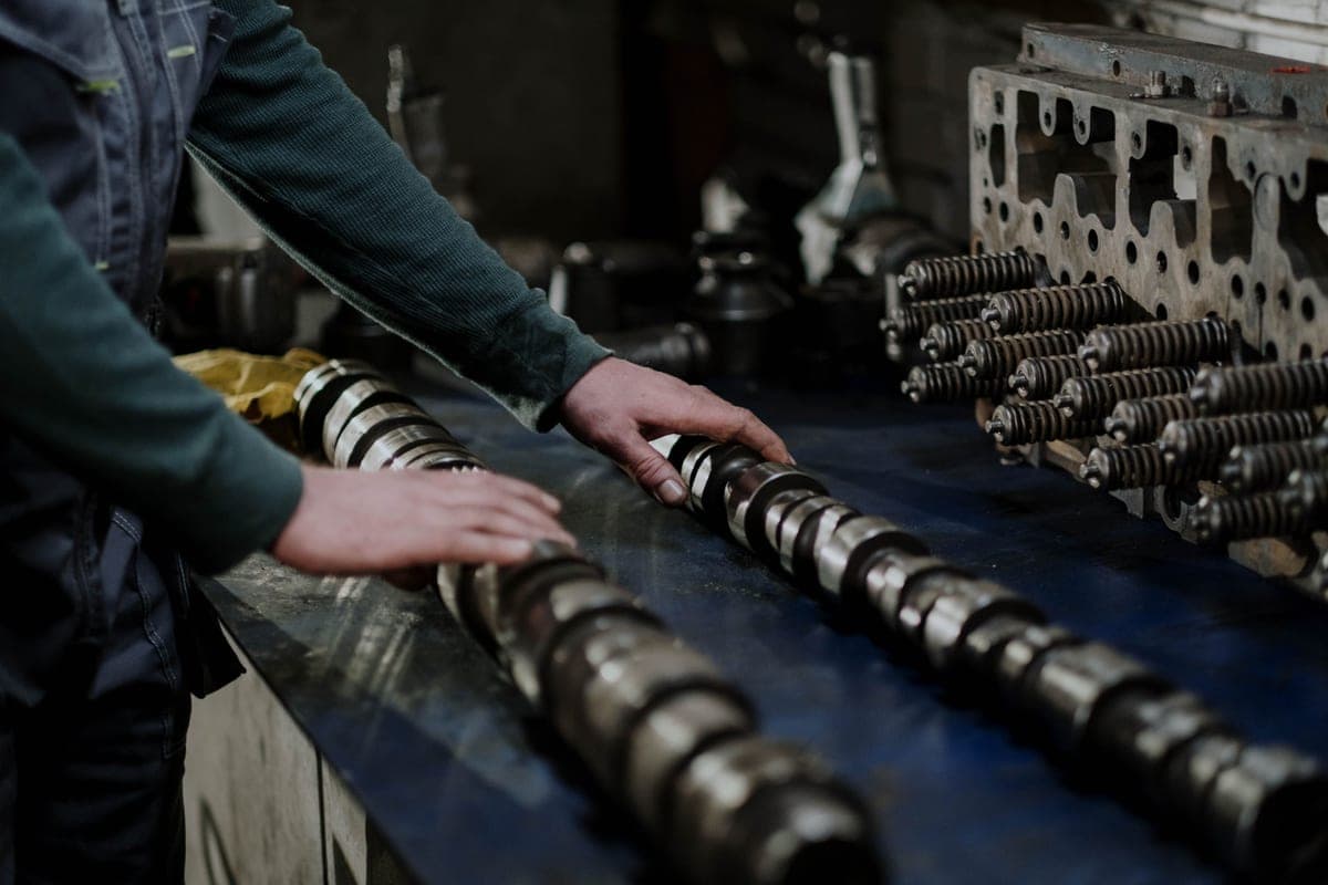 Camshafts and a cylinder head laid out on a workbench in a workshop